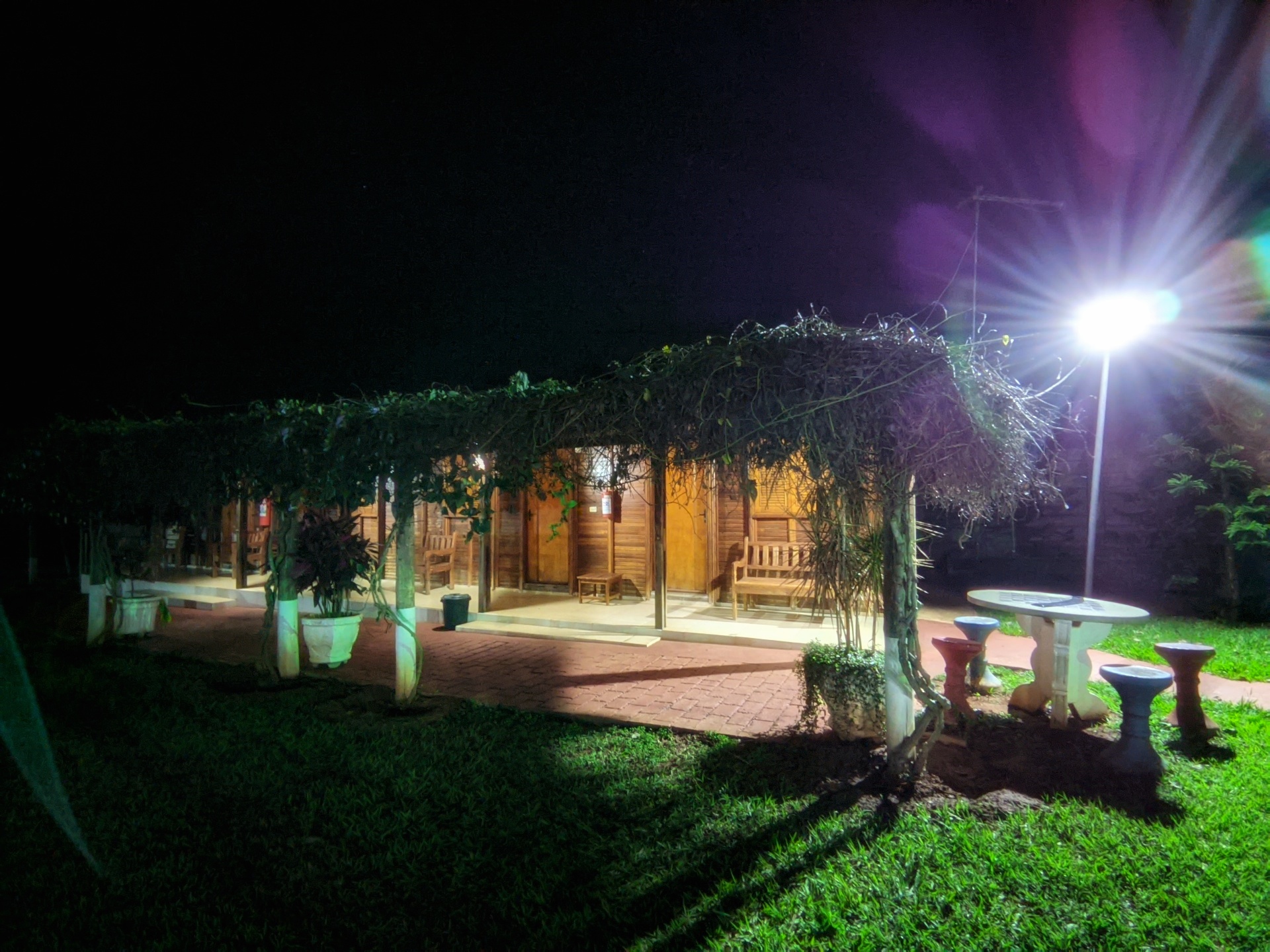 Pergolado florido e chalés de madeira iluminados à noite