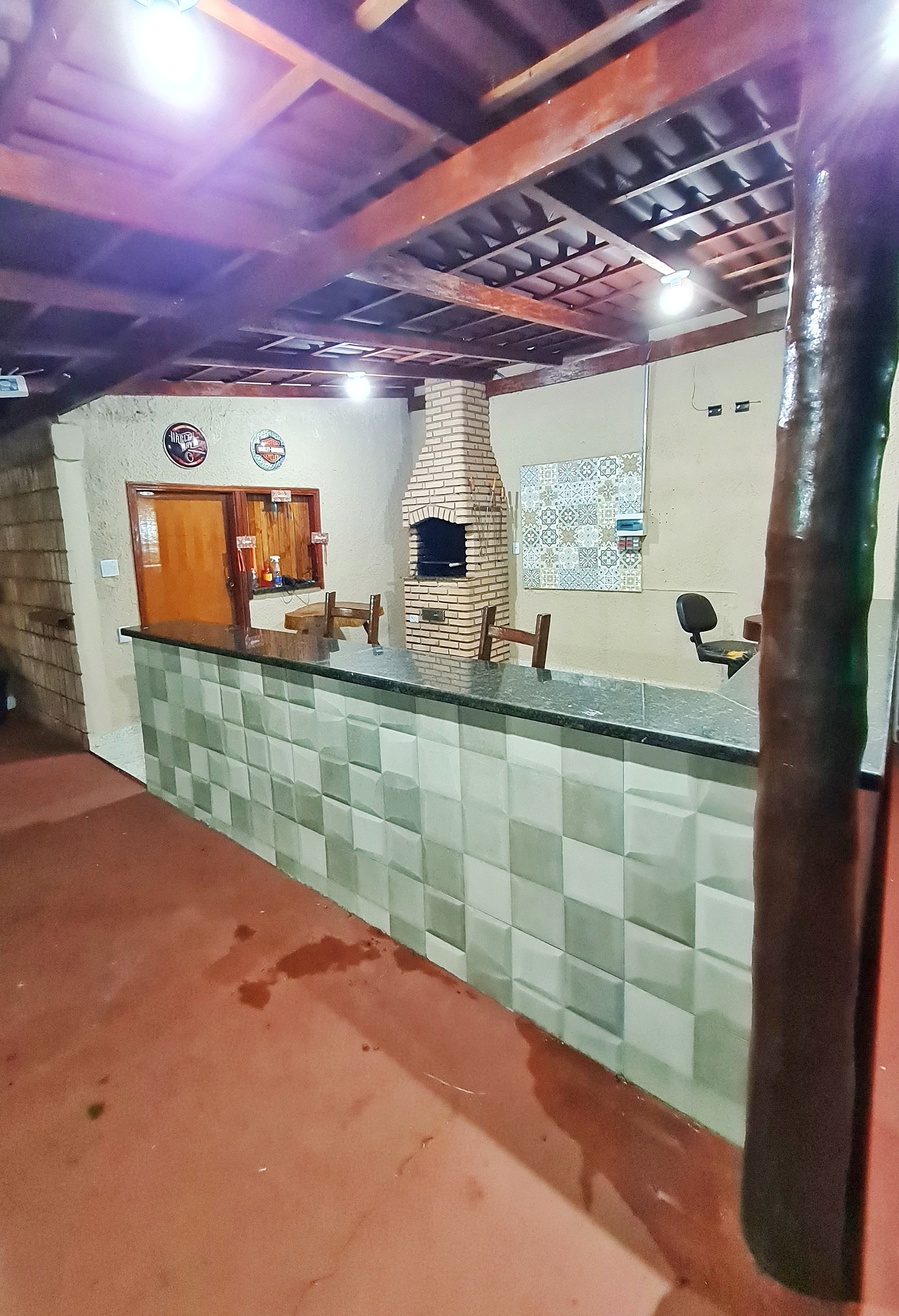 Mesa posta e churrasqueira acesa no espaço gourmet à noite