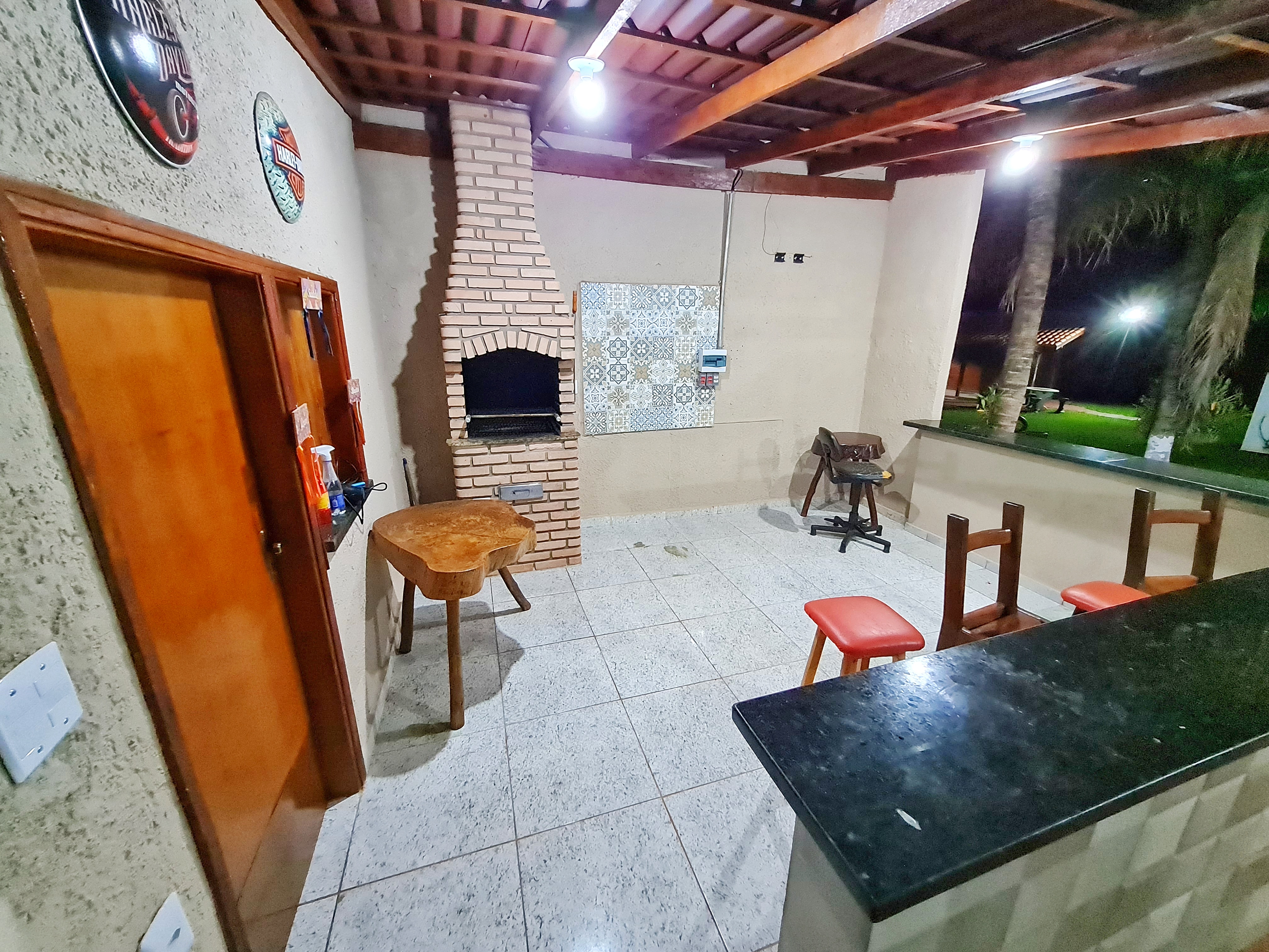 Churrasqueira acesa e mesa gourmet à noite