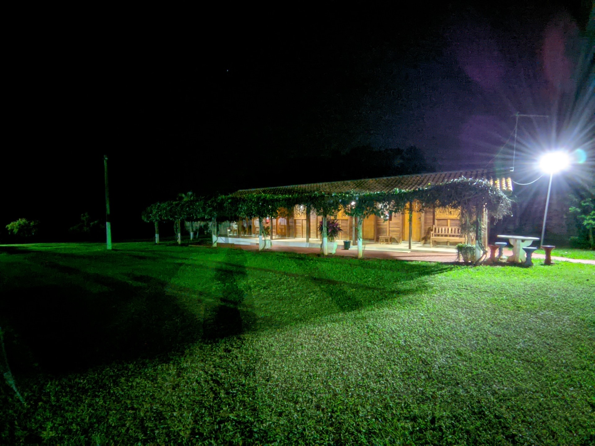 Gramado e caminhos iluminados por postes à noite