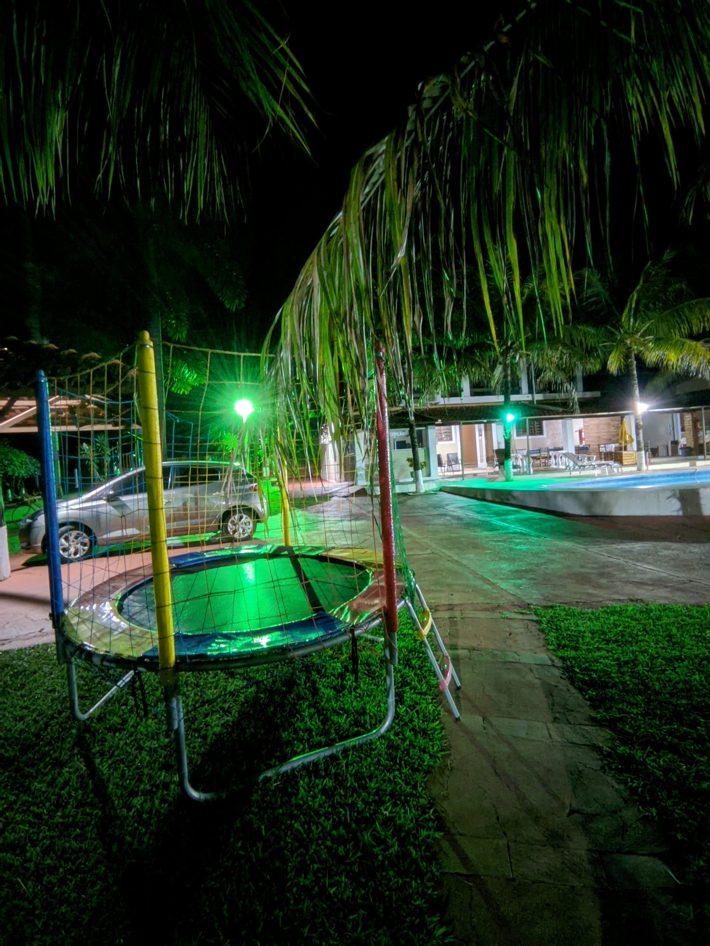 Cama elástica iluminada à noite no gramado